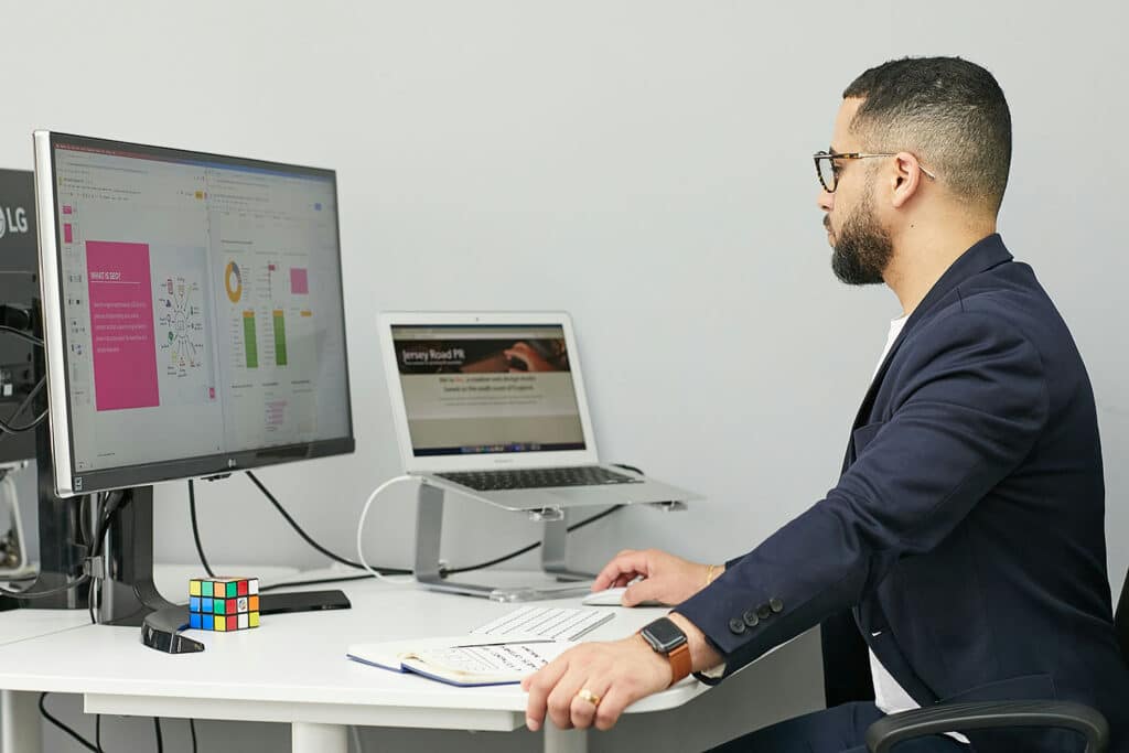 Entrepreneur analyzing key business valuation metrics like EBITDA, revenue growth, and churn rate on a laptop dashboard.